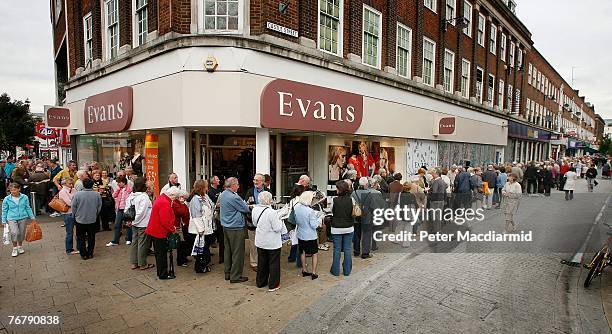 Customers wait in line to remove their savings from a branch of The Northern Rock bank on September 17, 2007 in Kingston-Upon-Thames, England....