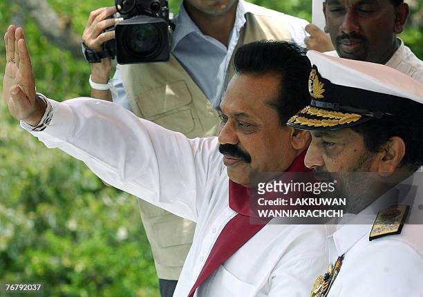 Sri Lankan President Mahinda Rajapakse flanked by Commander of the Navy, Rear Admiral Wasantha Karannagoda waves towards the Navy attack craft...