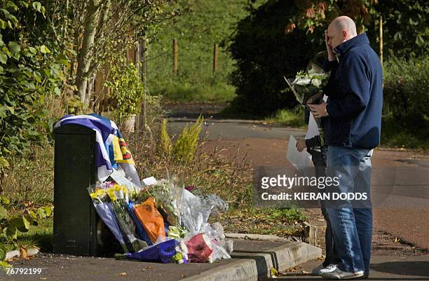 Fans of former world rally champion Colin McRae prepare to place flowers in his memory at the entrance to his home in Lanark, in Scotland, 17...