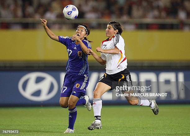 German player Ariane Hingst vies for the ball with Japan's Yuki Nagasato during the 2007 FIFA Women's World Cup soccer tournament Group A match...