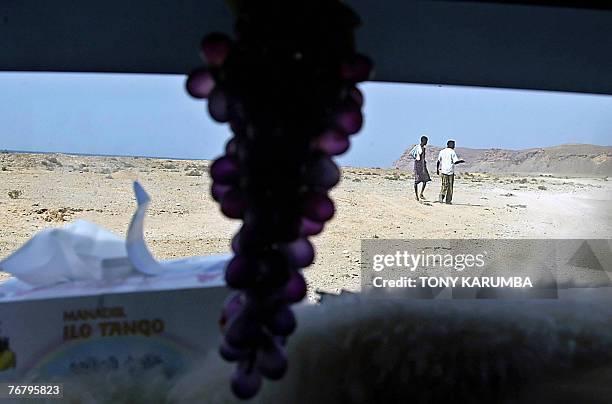 Two young men walk 07 September 2007 to meet smugglers at Shinbivale beach, 16 kilometers east of Bosasso, where Ethiopians and Somalians are...