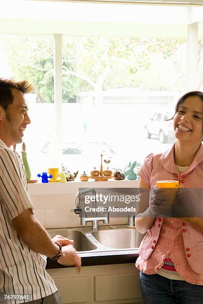 a man and a woman smiling in the kitchen - hand washing stock-fotos und bilder