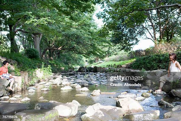 a girl and a boy at the opposite sides of the river - kid two sides stockfoto's en -beelden