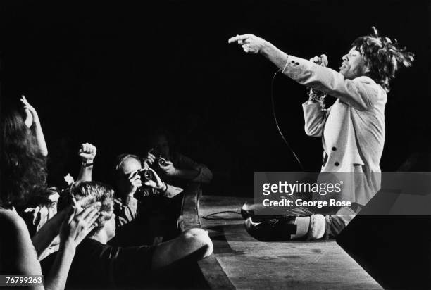 Mick Jagger, lead singer of the British rock band The Rolling Stones, gets down on his knees at the edge of the stage during a 1980 Atlanta, Georgia,...
