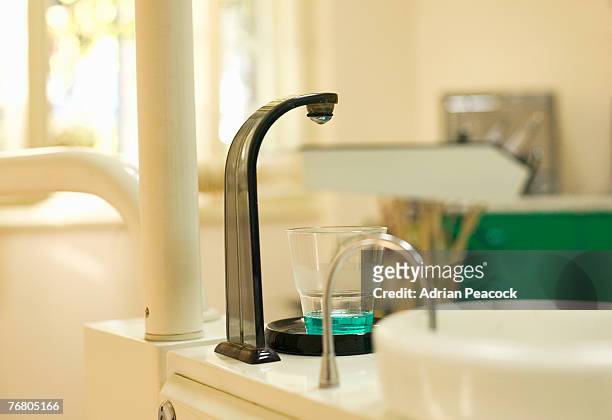 mouthwash dispenser at a dentist office - mouthwash stock-fotos und bilder