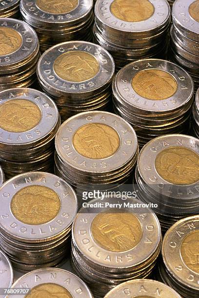 stacks of canadian two dollar coins - loonie stock pictures, royalty-free photos & images