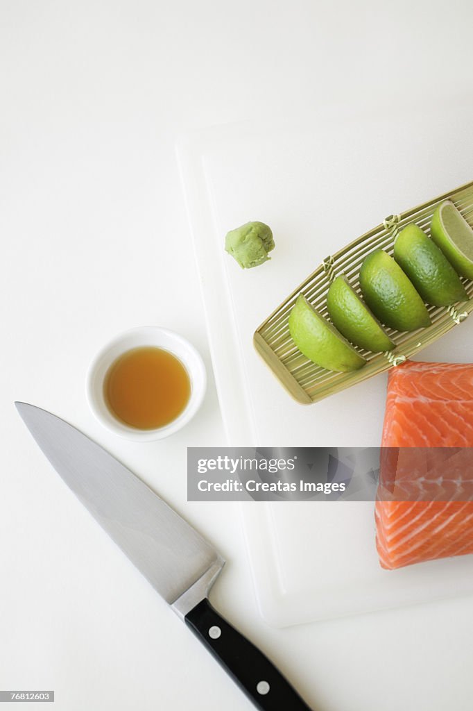 Raw salmon and limes with knife and sauce