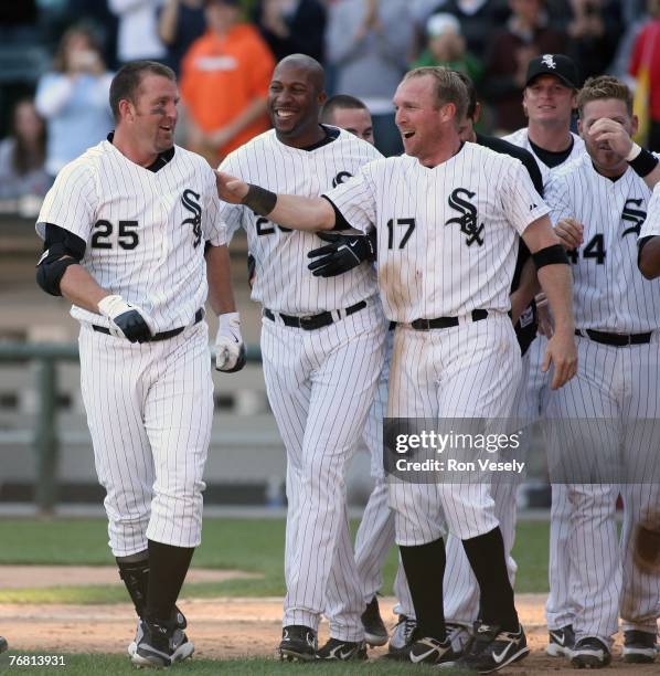 Jim Thome of the Chicago White Sox is greeted by Darin Erstad and Jermaine Dye after Thome hit his 500th career home run, a walk off home run winning...