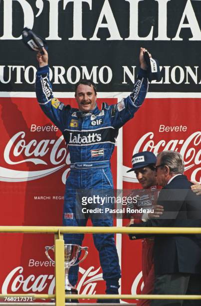 Nigel Mansell of Great Britain driver of the Canon Williams Renault Williams FW14Renault V10 salutes the crowd and celebrates his win as Jean-Marie...