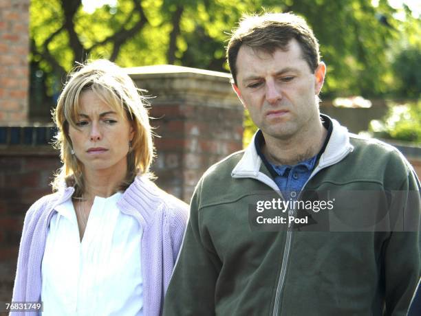 Kate and Gerry McCann walk outside their house as new spokesman Clarence Mitchell, a former BBC journalist, gives a statement to the press, September...