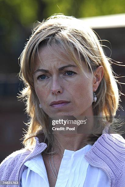 Kate and Gerry McCann walk outside their house as new spokesman Clarence Mitchell, a former BBC journalist, gives a statement to the press, September...