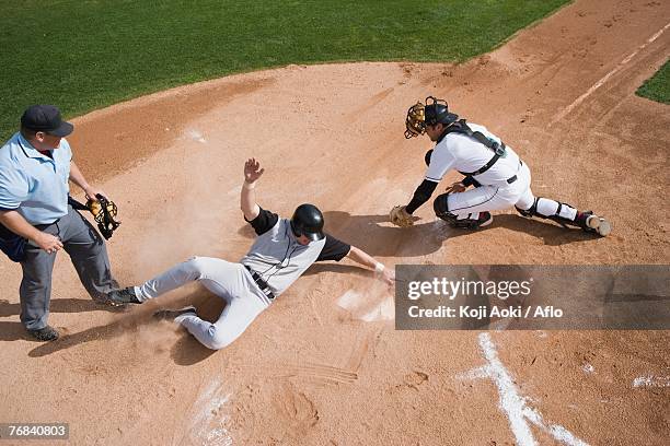 baseball player sliding into home plate - home base fotografías e imágenes de stock