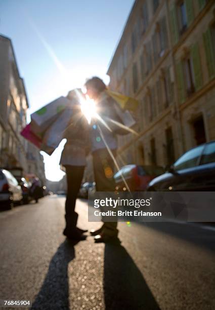 young couple standing in street, defocused (sun flare) - 馬賽族 個照片及圖片檔