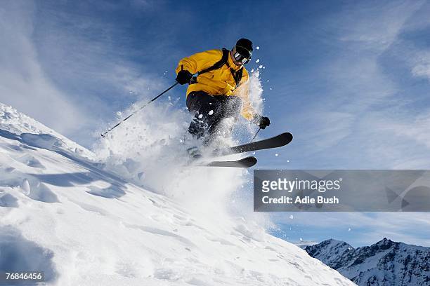 male skiing over mountain ridge - sport d'hiver photos et images de collection