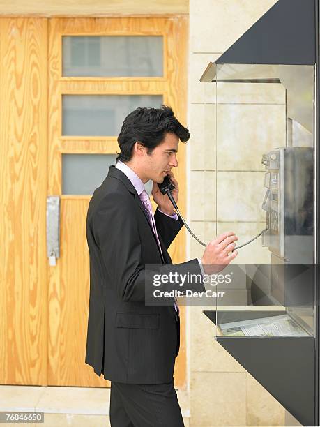 side view of young man in suit talking on public phone, alicante, spain, - pay phone stock pictures, royalty-free photos & images