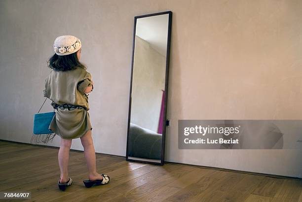 girl (2-4 years) dressing up for party, posing in mirror. - 2 3 years foto e immagini stock