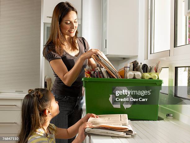 mother and daughter (4-6) filling recycling box, smiling - recycling fotografías e imágenes de stock