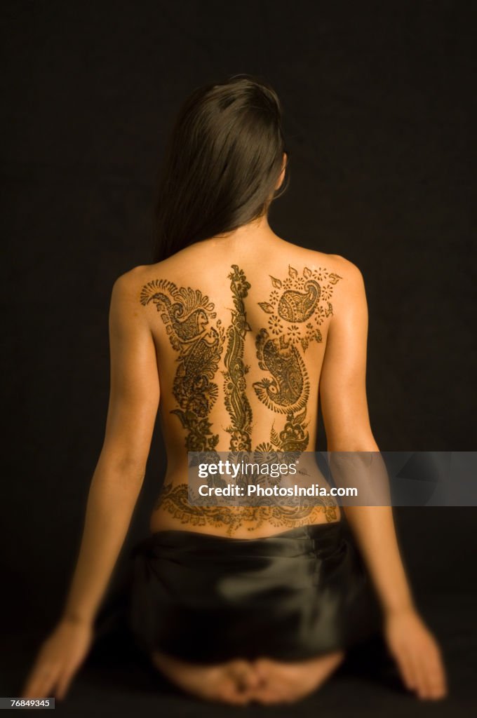 Rear view of a young woman with a tattoo on her back
