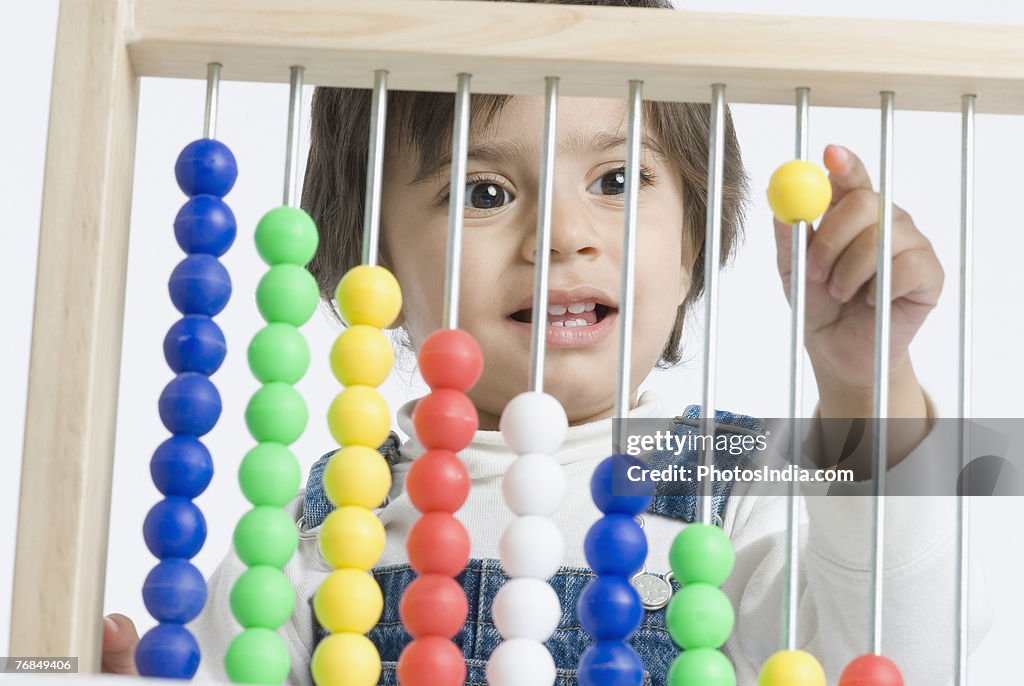 Close-up of a boy playing with an abacus