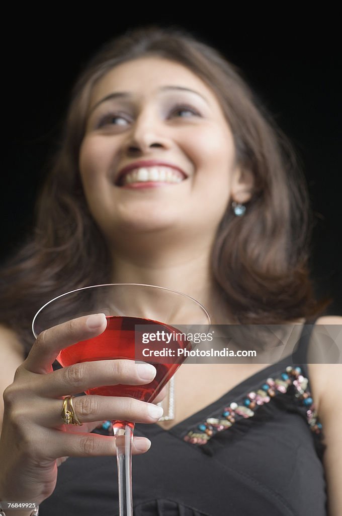 Low angle view of a young woman holding a martini