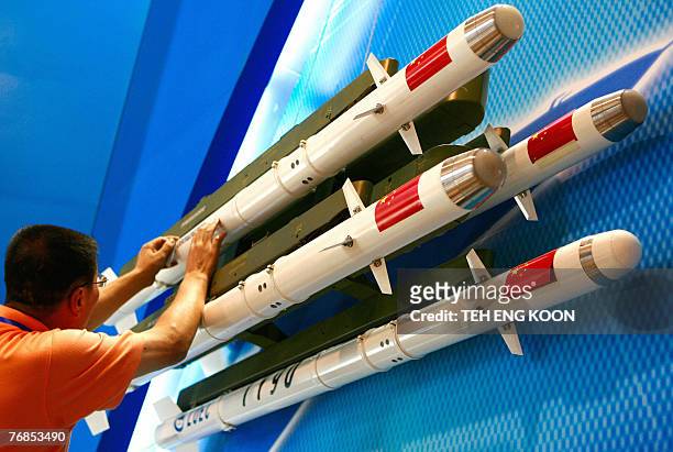 An exhibitor prepares Chinese made TY-90 IR missile models displayed on the opening day of the China Aviation Expo 2007 in central Beijing, 19...