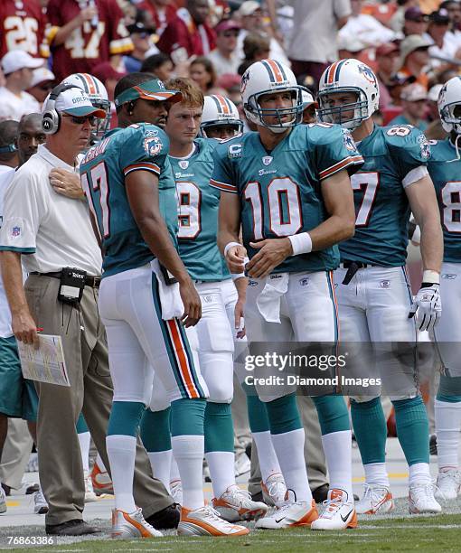 Head coach Cam Cameron of the Miami Dolphins confers with quaterbacks Cleo Lemon, John Beck and Trent Green on the sidelines during a game on...