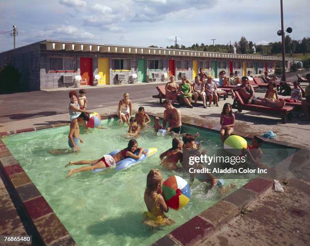 Sunbathers sit on deckchairs while children frolic in the kiddie pool at the Arca Manor motel, Arca, New York, 1960s.