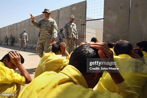 Juvenile detainees are counted by U.S. Army guards after a bathroom break at the "House of Wisdom" school run by the U.S. Military near the Camp...