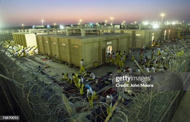 Iraqi detainees mill about and others pray at the Camp Cropper detention center September 19, 2007 in Baghdad, Iraq. U.S. Forces have a total of some...