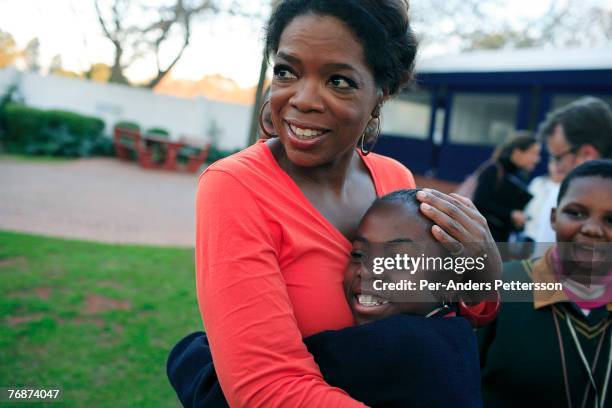 Oprah Winfrey hugs one of the girls that she interviewed for her school for unprivileged girls on August 10, 2006 in Johannesburg, South Africa....