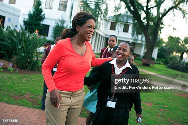 Oprah Winfrey holds one of the girls that she interviewed for her school for unprivileged girls on August 10, 2006 in Johannesburg, South Africa....