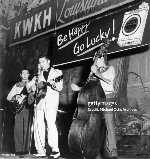 Singer Elvis Presley joins his guitar player Scotty Moore and bass player Bill Black on a weekly broadcast of "Lousiana Hayride" at the Shreveport...