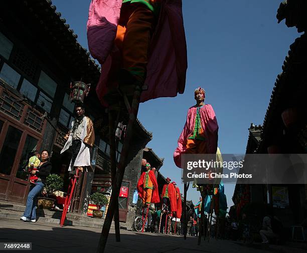 Stilt walkers perform at a street on September 20, 2007 in Pingyao of Shanxi Province, China. Pingyao, with a history of over 2,700 years, is a...