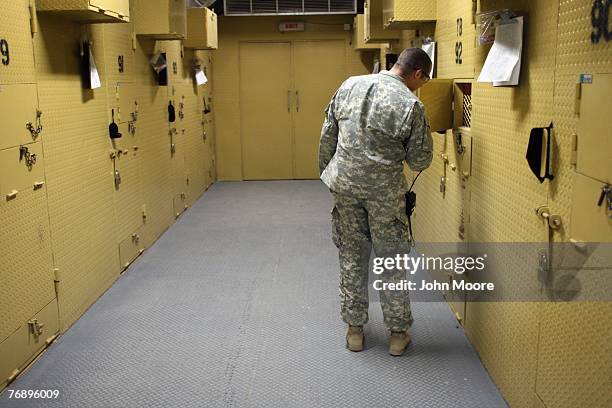 Army guard checks on detainees in solitary confinement cells at the Camp Cropper detention center September 20, 2007 in Baghdad, Iraq. The special...
