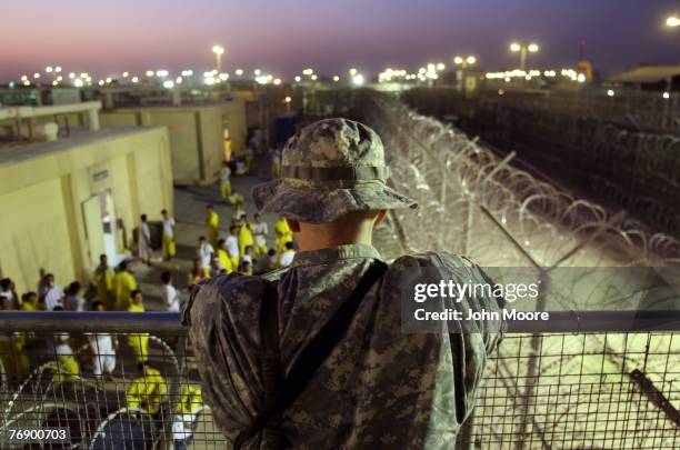 Army soldier watches Iraqi detainees at the Camp Cropper detention center September 19, 2007 in Baghdad, Iraq. U.S. Forces have a total of about...