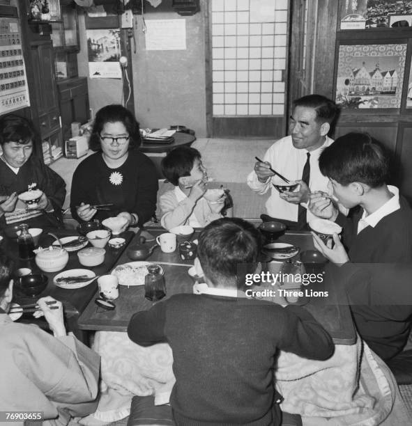 Family in Japan sit down to a meal together, circa 1965.