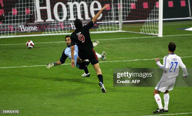 Bayern Munich's Italian striker Luca Toni shoots past Lisbon's goalkeeper Costinha to score during the UEFA cup football match Bayern Munich 04 vs....