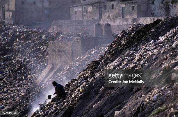 Man sits atop a hillside surrounded by garbage and rubble on December of 1996 in a demolished area of Kabul, Afghanistan. Afghanistan is no stranger...