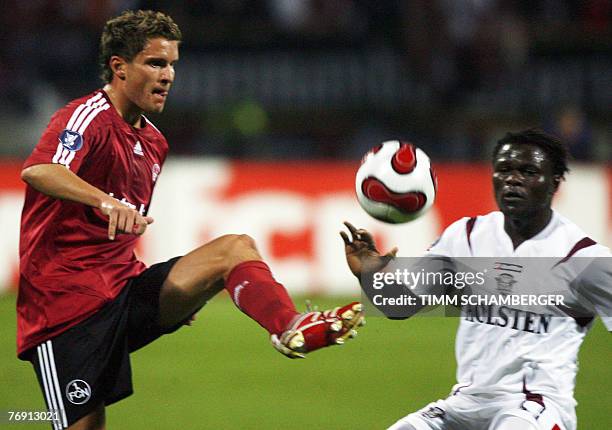 Nuernberg's Danish midfielder Jan Kristiansen and Bukarest's striker Pierre Boya vies for the ball during the the UEFA cup football match FC...