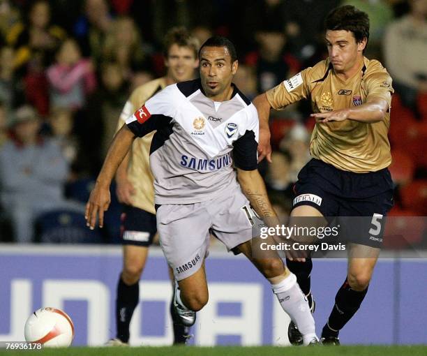 Archie Thompson of the Victory controls the ball ahead of Stuart Musialik of the Jets during the round five A-League match between the Newcastle Jets...