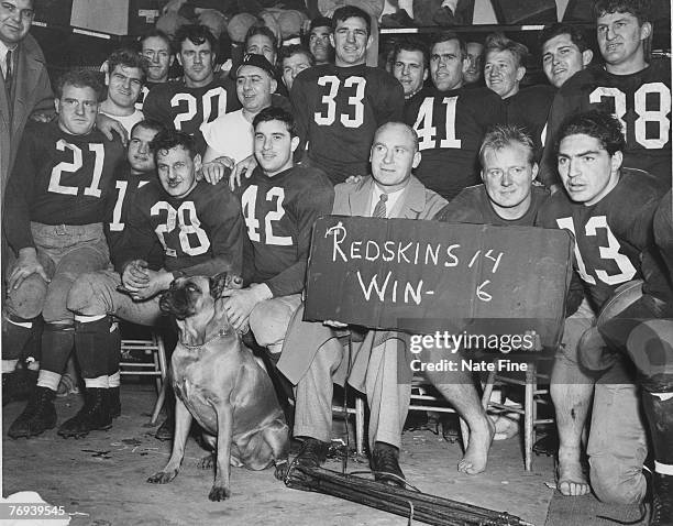 Head coach Ray Flaherty sits among his Washington Redskins players, including Hall of Fame quarterback Sammy Baugh after their 14-6 win over the...