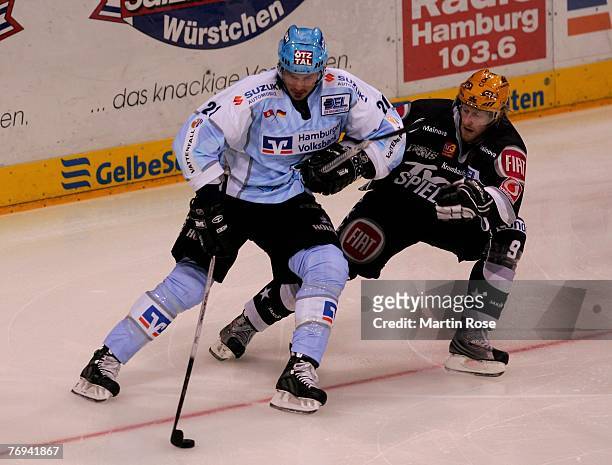 John Tripp of Hamburg and Lasse Kopitz of Frankfurt fight for the puck during the DEL match between Hamburg Freezers and Frankfurt Lions at the Color...