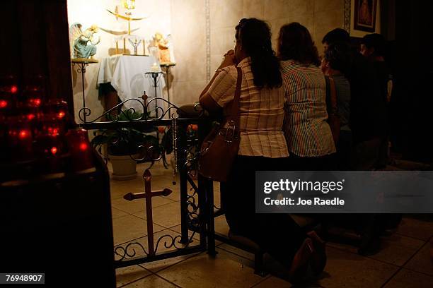 People pray in front of what many of them are saying is a shadow that has formed the silhouette of the Holy Family -- Joseph and the Virgin Mary...