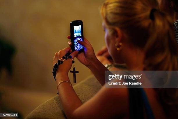 Susy Vazquez uses her camera phone to photograph a shadow that has formed what many think is the silhouette of the Holy Family -- Joseph and the...