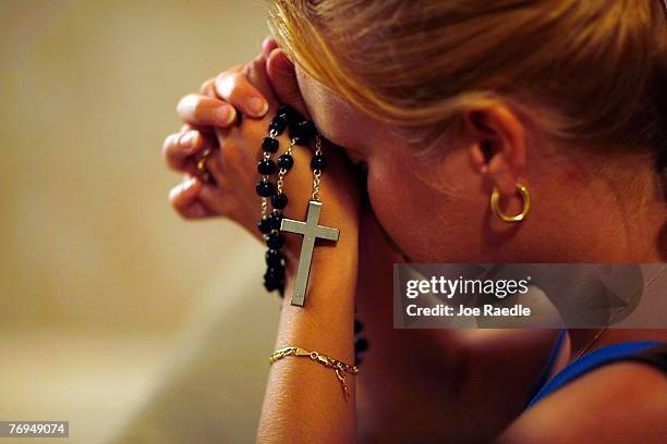 Susy Vazquez prays before a shadow that has formed what many think is the silhouette of the Holy Family -- Joseph and the Virgin Mary standing over...