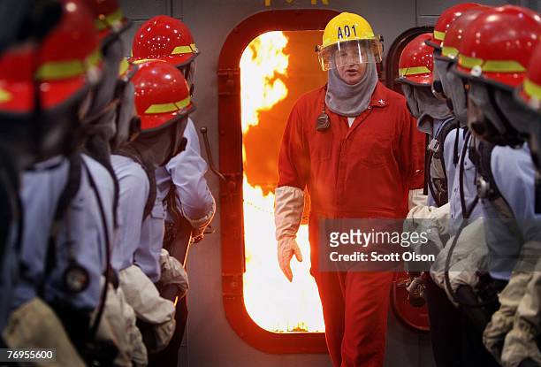 Gregory Burken, of Raleigh, North Carolina teaches United States Navy recruits firefighting with a simulated ship?s engine room fire during training...