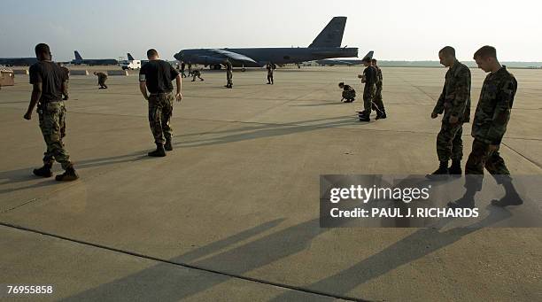 Members of the US Air Force ground crew scour the tarmac for Foreign Objects and Debris , a regular ritual on the tarmac as a US Air Force B-52H long...