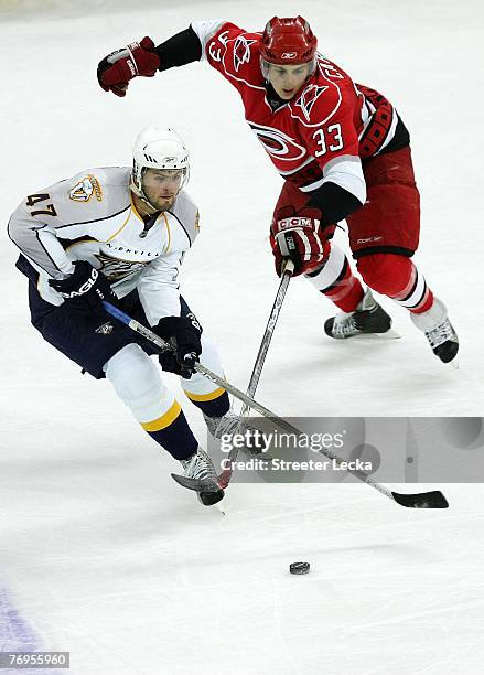Alexander Radulov of the Nashville Predators keeps the puck away from Brett Carson of the Carolina Hurricanes during their game at the RBC Center on...