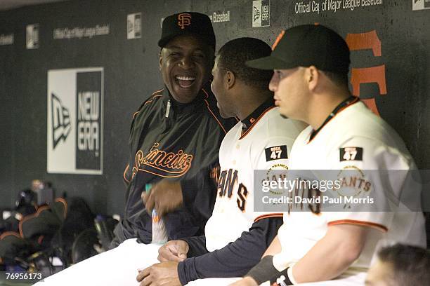 San Francisco Giants left fielder Barry Bonds watches the game from the Giants dugout after a press conference earlier in the day announcing the...