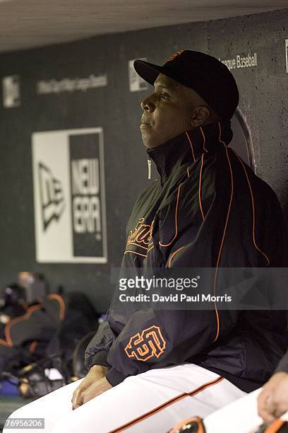 San Francisco Giants left fielder Barry Bonds watches the game from the Giants dugout after a press conference earlier in the day announcing the...